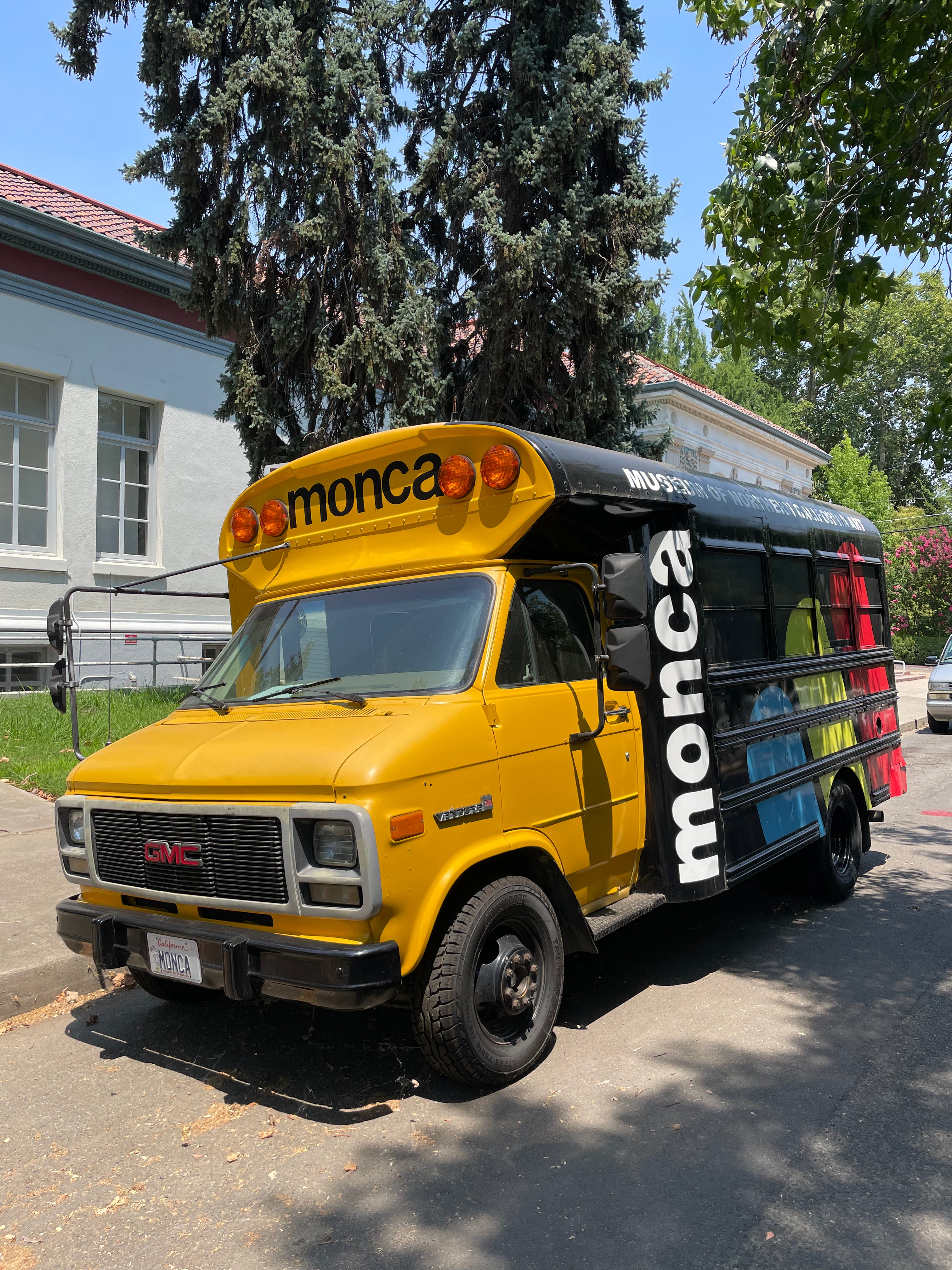 Yellow van with 'monca' branding parked on a street