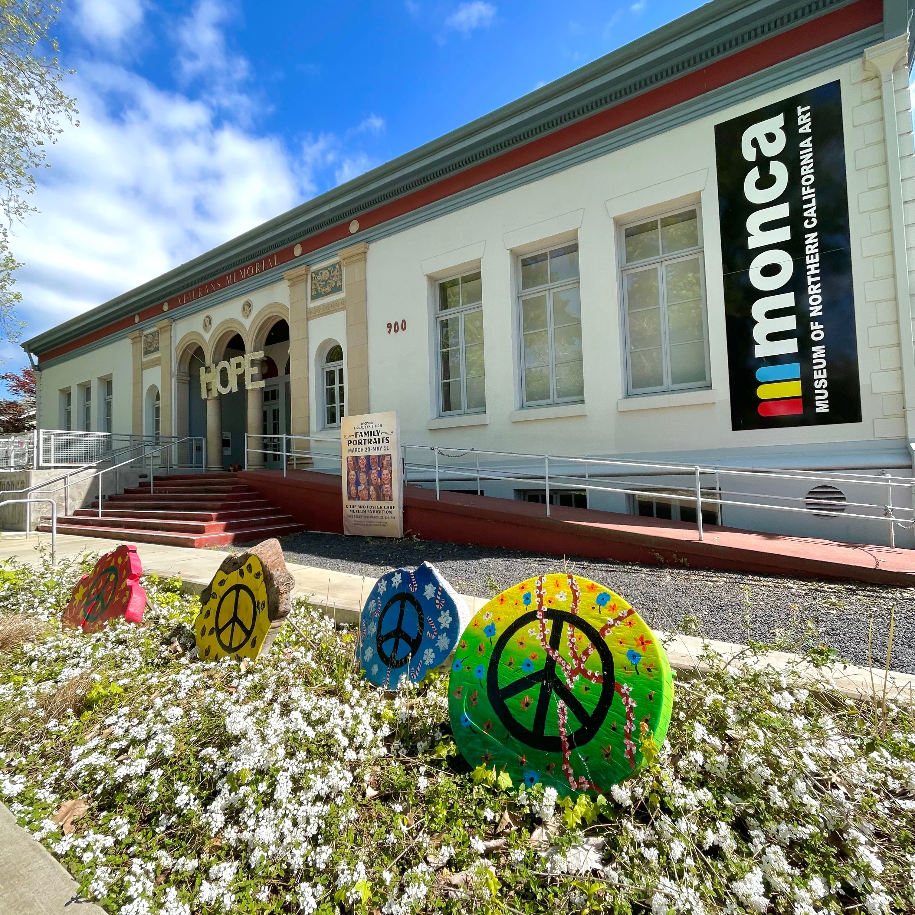 Building with 'ilmonca' sign and peace symbol decorations in front