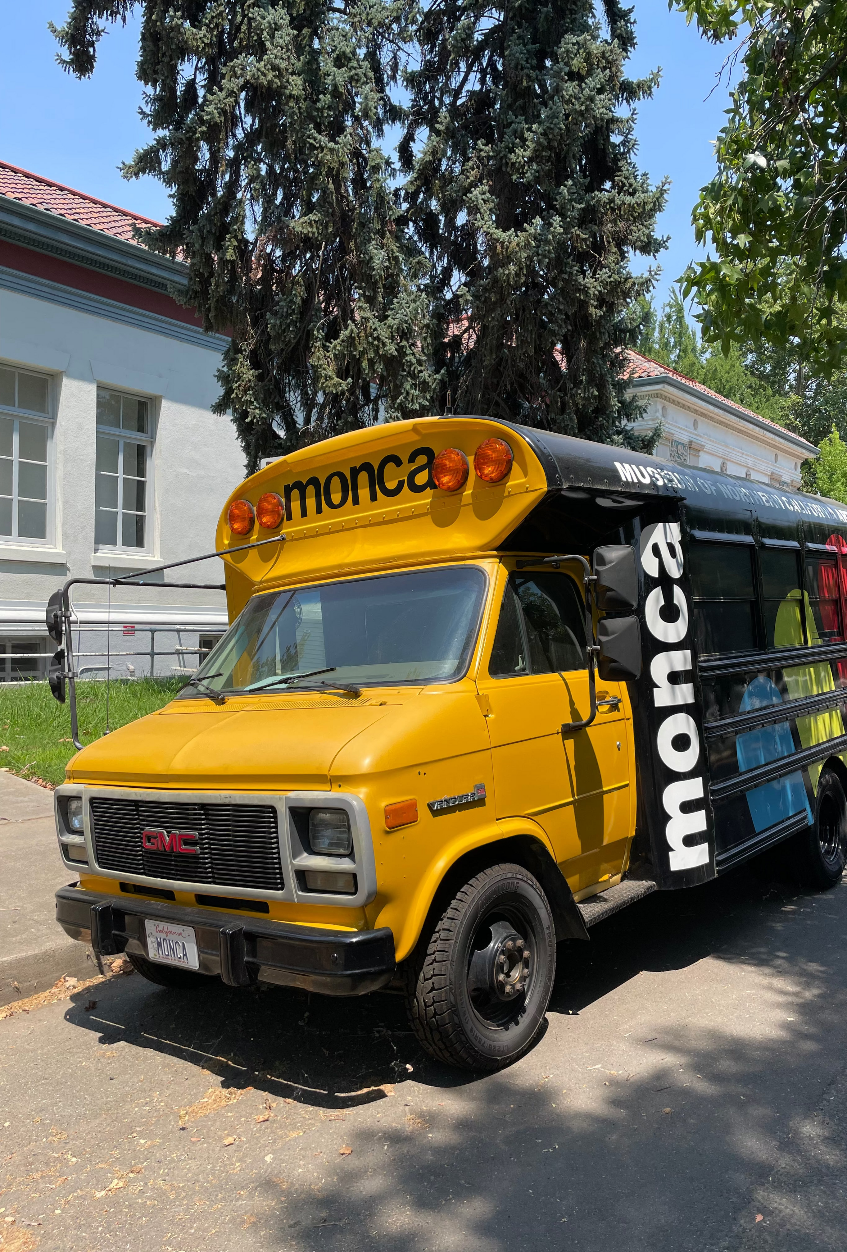 Yellow van with 'monca' branding parked on a street