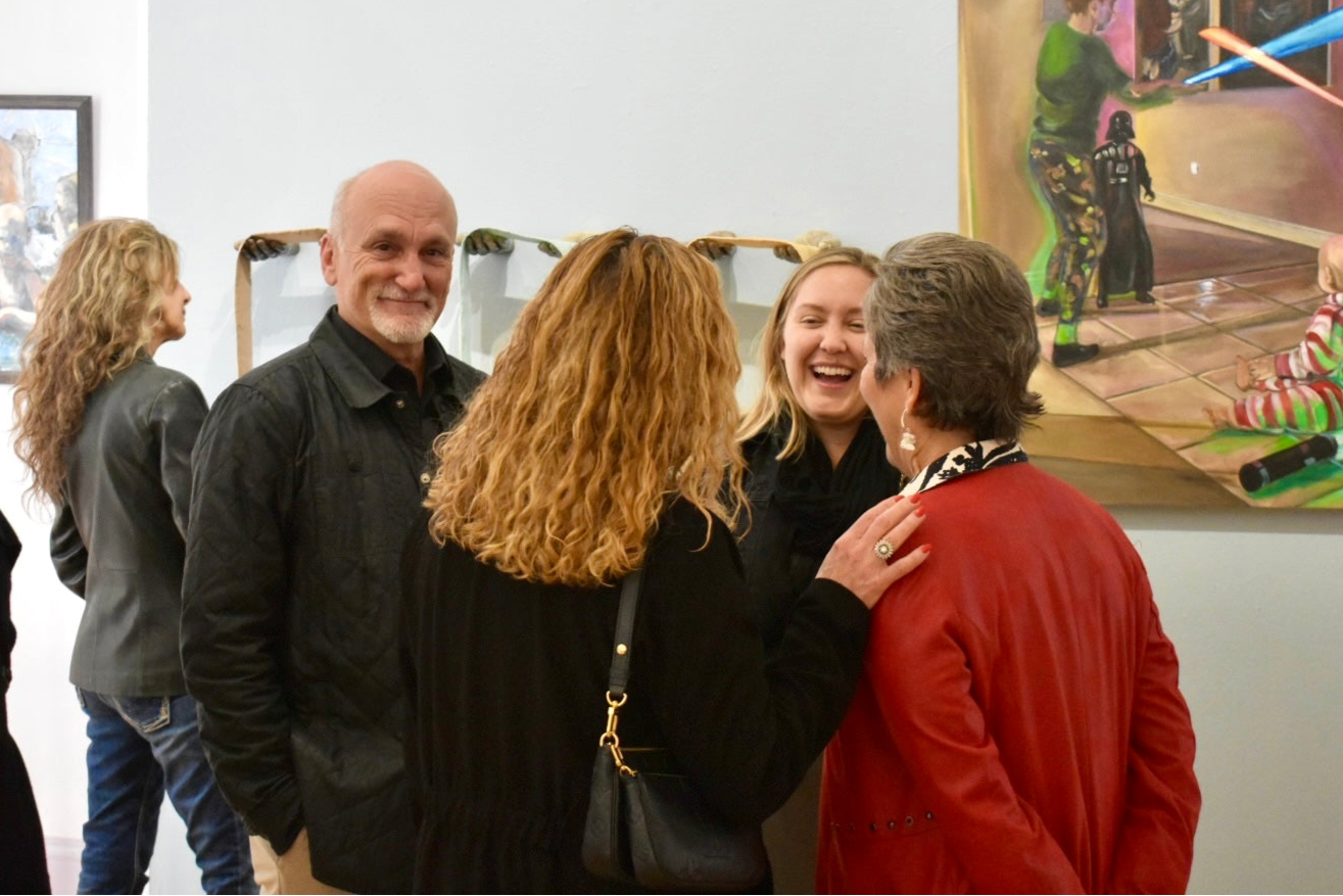 Group of people interacting in an art gallery setting